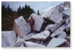 Sylvia stands amidst large blocks of marble